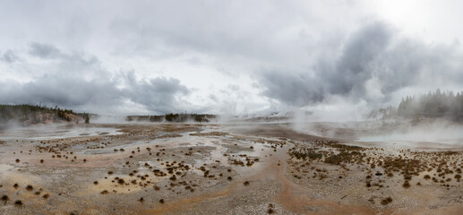 Hot spring Geyser with colorful water in American Landscape. Cloudy Sky. Yellowstone National Park, Wyoming, United States. Nature Background Panorama