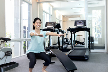 Fototapeta na wymiar Beautiful and shapely Asian woman working out in the gym, Play exercise machine treadmill, Dumbbell, stretching, Hanging bar, Barbell, Cardio, Stretch, Woman warming up in the gym, Jump rope.