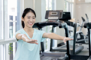 Plakat Beautiful and shapely Asian woman working out in the gym, Play exercise machine treadmill, Dumbbell, stretching, Hanging bar, Barbell, Cardio, Stretch, Woman warming up in the gym, Jump rope.
