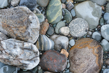 Background of rounded river stones of different colors from the river bank