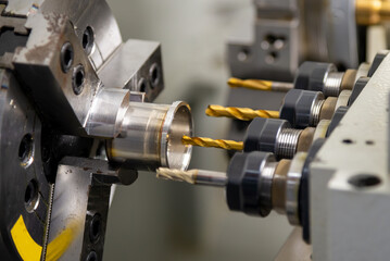 The  CNC multi-tasking machine swiss type  hole drilling the metal cylindrical shape parts.