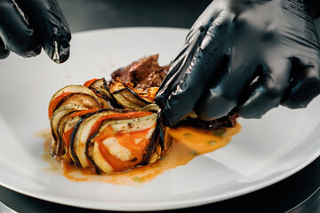Professional restaurant kitchen, close-up: sliced delicious juicy filet mignon steak and ratatouille