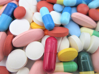    Different colored drugs and pills on the white laboratory table. Creative healthcare of medicine concept. Close the capsule stack. Flat laying.        
