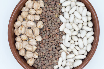 Bol con legumbres, lentejas, garbanzos sobre fondo blanco.
