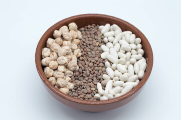 Bol con legumbres, lentejas, garbanzos sobre fondo blanco.