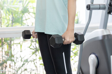 Beautiful and shapely Asian woman working out in the gym, Play exercise machine treadmill,...