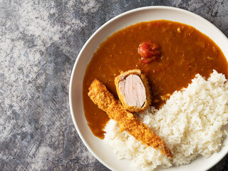 Curry and shrimp tempura and meat on a plate