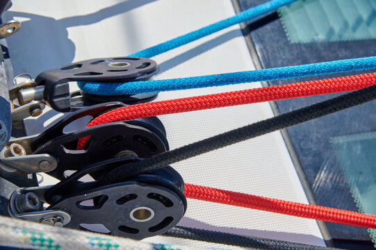 Umlenkrollen mit farbigen  Leinen auf einem Segelschiff