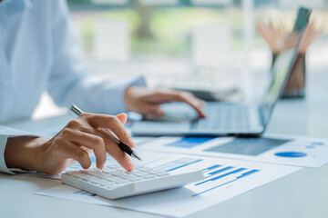 An accountant, businessman or financial professional presses calculators, computes, analyzes...