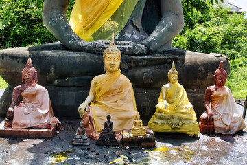 Small, colourful buddha statues in front of a large black buddha statue, Wiang Kum Kam...