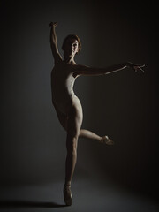 charming ballerina posing in the studio on a dark background