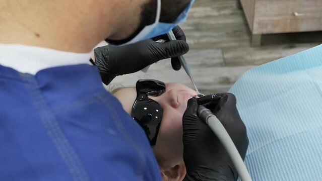 A Male Pediatric Dentist Was Assigned To Drill A Tooth To Fill Caries In A Small Patient. The Child Is Treated With A Tooth In The Prone Position, Wearing Goggles From The Light Of The Lamp