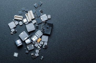 Top view of various electronic components on black background. - obrazy, fototapety, plakaty