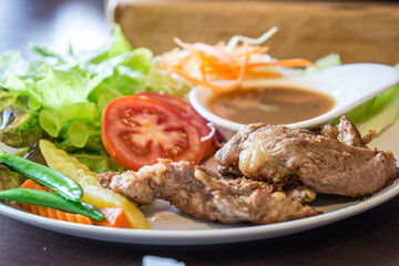 Pork steak in a plate with green peas and tomatoes