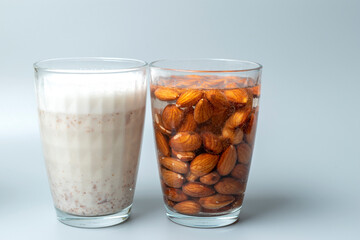 Side view of glasses with almonds nuts and almonds nuts milk.