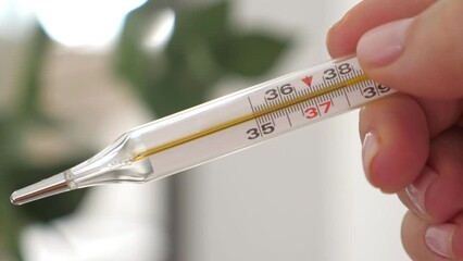 Thermometre with high temperature in female hand, closeup
