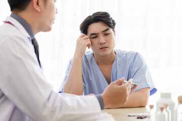 Professional doctor interacting with patient sitting on chair, Male patient get advice about medicine from doctor at hospital