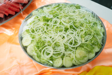 Cutted cabbage, onion and cucumber store in steel bowl and seal with platic wrap