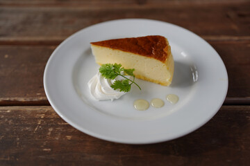 Cheese cakes on white plates with wooden table background