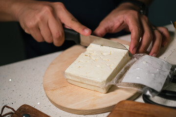Fototapeta na wymiar Wine tasting appetizer prepration in progress which start from cutting brie cheese.