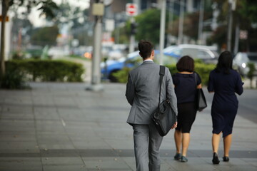 man with 2 girl walking on the street 