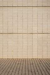Texture of a stone wall with beige bricks at the street in the morning. Pattern of decorative wall as a background