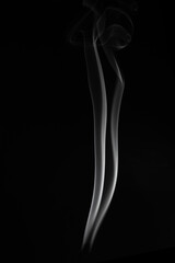 A single white smoke burn from incense, shot in studio with dark black background, for design and religion concept