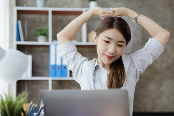 Working woman relaxing, a businesswoman in office, she is relaxing after working hard for a long time, causing fatigue and stress to take a break, she has office syndrome. Hard work concept.