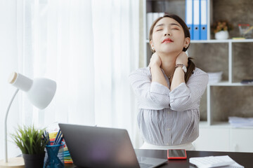 Working woman relaxing, a businesswoman in office, she is relaxing after working hard for a long time, causing fatigue and stress to take a break, she has office syndrome. Hard work concept.