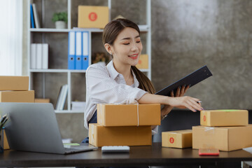 A woman who owns an online store counting parcels to be delivered to customers, she sells online and packs through a private shipping company. concept of a woman opening an online business.