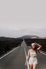 joven chica disfrutando sus vacaciones caminando en una larga carretera en Lanzarote en el parque Nacional del Timanfaya