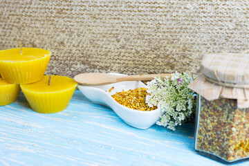 raw organic bee pollen on a wooden board surrounded by wildflowers - obrazy, fototapety, plakaty