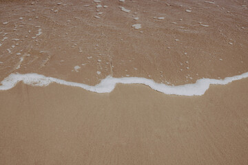 Seascape, waves, sun, sand, foam.