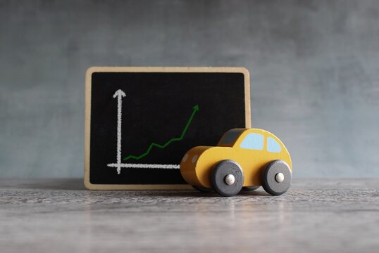 Toy Car And Chalkboard With Upward Arrow Graph. Car Rental Dealer Sales Profit Increase Concept.