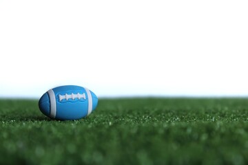 Selective focus image of rugby ball on rugby pitch grass isolated on white background