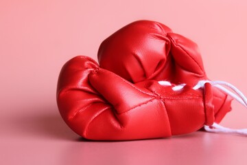Close up image of red boxing gloves on pink background. Sports concept