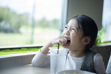 Asian girl enjoy eating food for breakfast or lunch in restaurant.