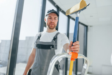 Cleaning service. Repairman is working indoors in the modern room