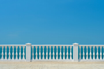 Summer view with classic white balustrade and empty terrace overlooking the mediterranean sea, vacation idea. Free space for text