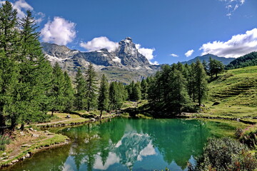 Naklejka na ściany i meble Summer alpine landscape with the Matterhorn (Cervino) reflected on the Blue Lake (Lago Blu) near Breuil-Cervinia. Aosta Valley, Italy - August 2022