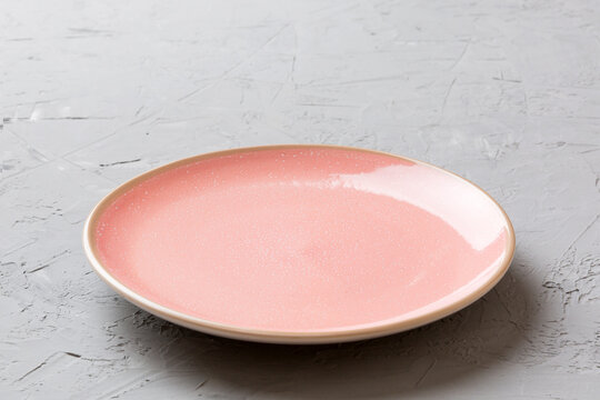 Perspective view of empty pink plate on cement background. Empty space for your design