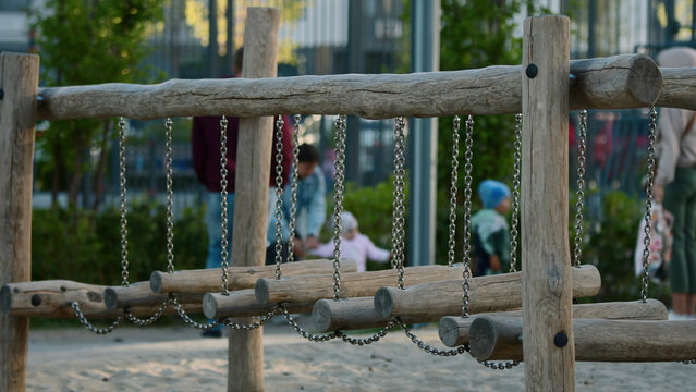 Large Playground. Stock Footage. Wooden Bars For Children, Running Children And Their Parents Are Visible From Behind