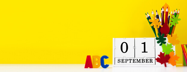 Horizontal yellow banner for the new school year. Back to school background. Calendar on the table...
