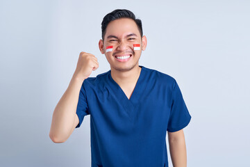 Handsome Asian man wearing blue male nurse uniform celebrating indonesian independence day August 17 isolated on white background studio portrait