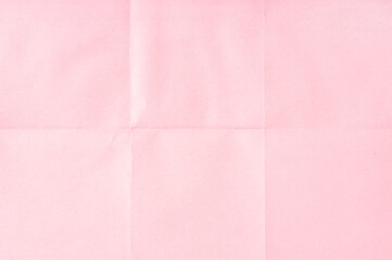 Pink crumpled unfolded paper sheet texture background. Paper folded in six. Full frame