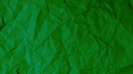 The green paper background is wrinkled, creating a rough texture with light and shadow.