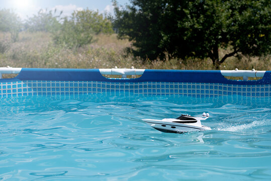boat in the pool splashing water. children's toy on the radio control. summer games