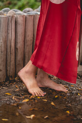 Sexy feet of young japanese girl with beautiful old traditional red kimono stepping on the mud in a...