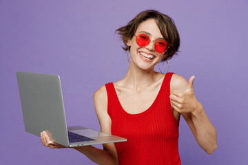 Young smiling programmer fun happy freelancer woman she wearing red tank shirt eyeglasses hold use...