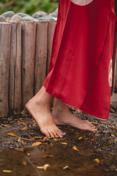 Sexy feet of young japanese girl with beautiful old traditional red kimono stepping on the mud in a japanese garden